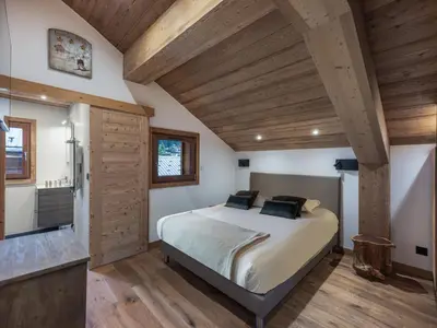 a bedroom with a bed in a room with wooden ceilings at Appartement rénové au centre de Megève avec balcon et parking - FR-1-569-137 in Megève