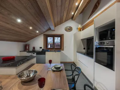 a kitchen with a wooden table and a wooden ceiling at Appartement rénové au centre de Megève avec balcon et parking - FR-1-569-137 in Megève