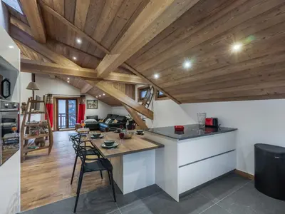 a kitchen and living room with wooden ceilings at Appartement rénové au centre de Megève avec balcon et parking - FR-1-569-137 in Megève
