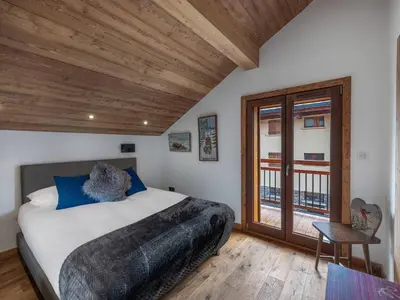a bedroom with a bed and a wooden ceiling at Appartement rénové au centre de Megève avec balcon et parking - FR-1-569-137 in Megève