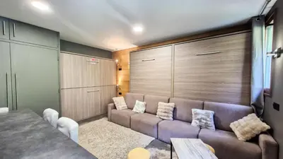 a living room with a couch and some cabinets at Résidence Vega - Studio rénové · Proche des pistes et des commerces MAE-2831 in Magland