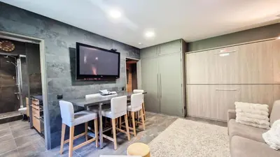 a living room with a table and a tv on a wall at Résidence Vega - Studio rénové · Proche des pistes et des commerces MAE-2831 in Magland