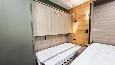 a small room with a bed and a closet at Résidence Vega - Studio rénové · Proche des pistes et des commerces MAE-2831 in Magland