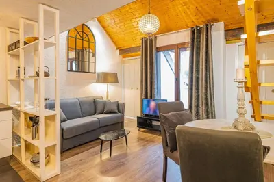 a living room with a couch and a table at Chamour - A duplex apartment with Mont-Blanc view in Chamonix-Mont-Blanc