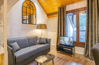 a living room with a couch and a tv at Chamour - A duplex apartment with Mont-Blanc view in Chamonix-Mont-Blanc