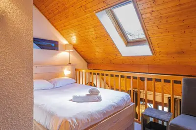 a bedroom with a bed and a skylight at Chamour - A duplex apartment with Mont-Blanc view in Chamonix-Mont-Blanc