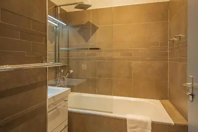 a bathroom with a tub and a glass shower at Chamour - A duplex apartment with Mont-Blanc view in Chamonix-Mont-Blanc
