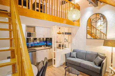 a living room with a couch and a kitchen at Chamour - A duplex apartment with Mont-Blanc view in Chamonix-Mont-Blanc