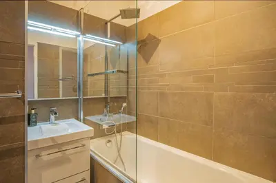 a bathroom with a tub and a sink and a shower at Chamour - A duplex apartment with Mont-Blanc view in Chamonix-Mont-Blanc