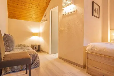 a room with two beds and a table and a lamp at Chamour - A duplex apartment with Mont-Blanc view in Chamonix-Mont-Blanc