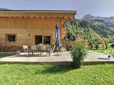 a woman standing on a wooden deck with an umbrella at Le Vivier in Saint-Gervais-les-Bains