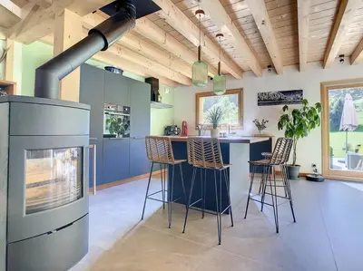 a kitchen with a stove and bar stools at Le Vivier in Saint-Gervais-les-Bains