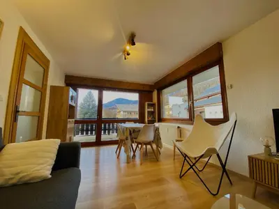 a living room with a table and chairs and windows at Charmant appartement rénové au cœur de Samoëns, proche skibus - FR-1-624-145 in Samoëns