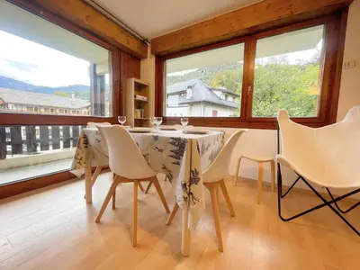 a dining room with a table and chairs and windows at Charmant appartement rénové au cœur de Samoëns, proche skibus - FR-1-624-145 in Samoëns