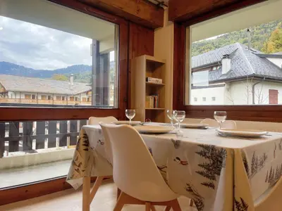a dining room with a table and a large window at Charmant appartement rénové au cœur de Samoëns, proche skibus - FR-1-624-145 in Samoëns