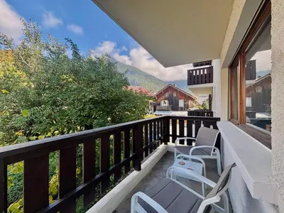 a balcony with chairs and a view of a house at Charmant appartement rénové au cœur de Samoëns, proche skibus - FR-1-624-145 in Samoëns