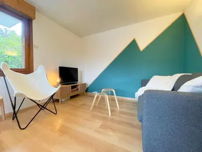 a bedroom with a bed and a chair and a tv at Charmant appartement rénové au cœur de Samoëns, proche skibus - FR-1-624-145 in Samoëns