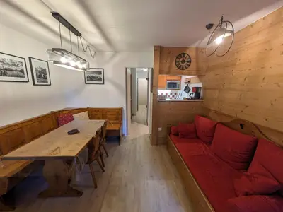 a living room with a red couch and a table at Appartement cosy à Chamonix pour 4, balcon, parking - FR-1-343-250 in Chamonix-Mont-Blanc