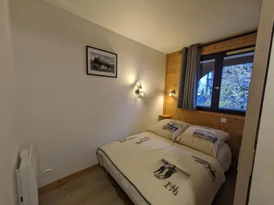 a bedroom with a bed and a window at Appartement cosy à Chamonix pour 4, balcon, parking - FR-1-343-250 in Chamonix-Mont-Blanc