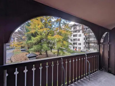 a balcony with an arched window looking out at a tree at Appartement cosy à Chamonix pour 4, balcon, parking - FR-1-343-250 in Chamonix-Mont-Blanc