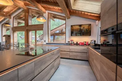 a kitchen with wooden cabinets and a large window at Chalets ASA 426 m2 in Chamonix-Mont-Blanc