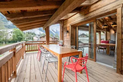 a wooden deck with a wooden table and chairs at Chalets ASA 426 m2 in Chamonix-Mont-Blanc