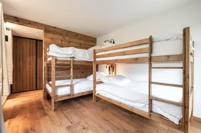 two bunk beds in a room with wooden floors at Chalets ASA 426 m2 in Chamonix-Mont-Blanc