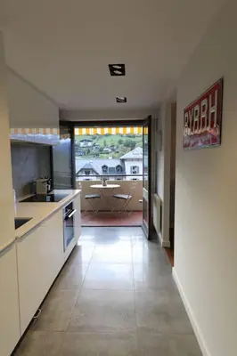 a large kitchen with a view of a living room at Modern and stylish 3-bedroom apartment with views - centre of St Gervais in Saint-Gervais-les-Bains