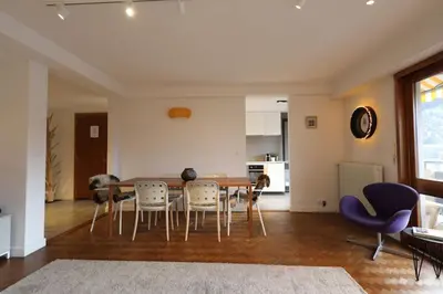 a living room with a dining room table and chairs at Modern and stylish 3-bedroom apartment with views - centre of St Gervais in Saint-Gervais-les-Bains