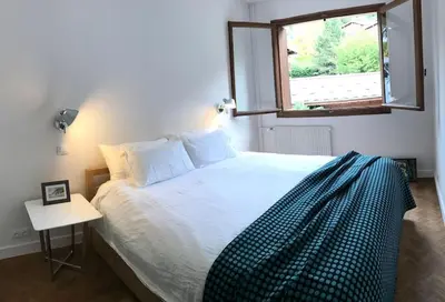 a bedroom with a large bed with a window at Modern and stylish 3-bedroom apartment with views - centre of St Gervais in Saint-Gervais-les-Bains