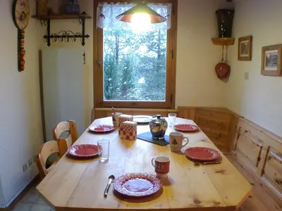 a wooden table with red plates on it in a kitchen at Appartement 2 pièces avec mezzanine, casier à skis et parking privatif à Samoëns - FR-1-629-135 in Samoëns