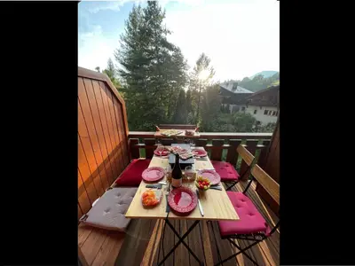 a wooden table with plates of food on a deck at Appartement 2 pièces avec mezzanine, casier à skis et parking privatif à Samoëns - FR-1-629-135 in Samoëns