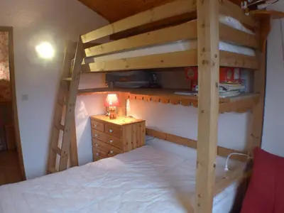 a bedroom with two bunk beds and a dresser at Appartement 2 pièces avec mezzanine, casier à skis et parking privatif à Samoëns - FR-1-629-135 in Samoëns