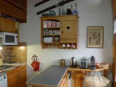 a kitchen with wooden cabinets and a counter top at Appartement 2 pièces avec mezzanine, casier à skis et parking privatif à Samoëns - FR-1-629-135 in Samoëns