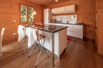 a kitchen with a island in a log cabin at Chalet aux Cerfs - Maison pour 10 vue montagne in Arâches-la-Frasse