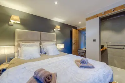 a bedroom with a large bed with towels on it at A 2 min du télécabine Chalet de charme 4 étoiles in Les Houches