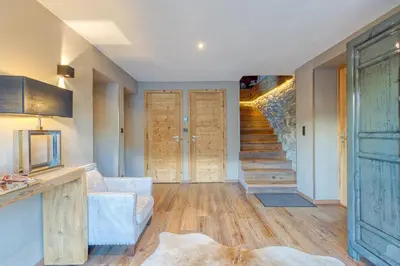 a living room with wooden floors and a staircase at A 2 min du télécabine Chalet de charme 4 étoiles in Les Houches