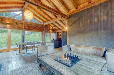 a living room with a couch and a chess board at A 2 min du télécabine Chalet de charme 4 étoiles in Les Houches