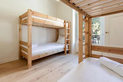 a room with two bunk beds and a window at Majestic - Appartement 2 pas du centre-ville Chamo in Chamonix-Mont-Blanc