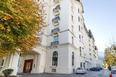 a white building with cars parked in front of it at Majestic - Appartement 2 pas du centre-ville Chamo in Chamonix-Mont-Blanc