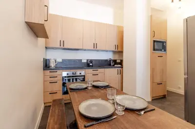a kitchen with a table with plates and wine glasses at Majestic - Appartement 2 pas du centre-ville Chamo in Chamonix-Mont-Blanc