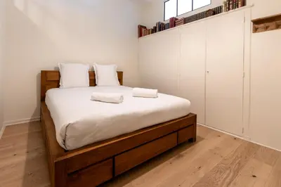 a bedroom with a bed with white sheets and white cabinets at Majestic - Appartement 2 pas du centre-ville Chamo in Chamonix-Mont-Blanc