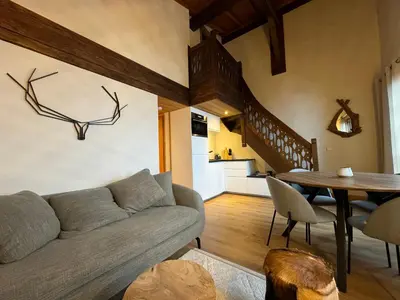 a living room with a couch and a table at Chalet LE REPAIRE proches des Pistes in Megève