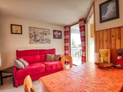 a living room with a red couch and a table at Confortable 2 pièces sans ascenseur, pour 4/5 pers., Morillon 1100 - FR-1-642-63 in Morillon