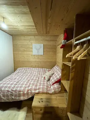 a small bedroom with a bed in a wooden room at Très bel appartement spacieux in Les Carroz d'Araches
