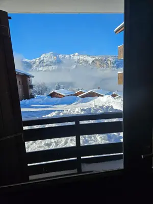 a view of a snowy mountain from a window at Très bel appartement spacieux in Les Carroz d'Araches