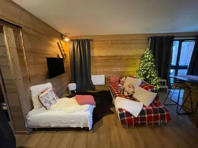 a living room with a christmas tree and two couches at Très bel appartement spacieux in Les Carroz d'Araches