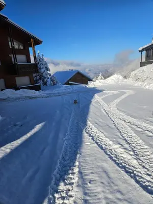 a road covered in snow next to a house at Très bel appartement spacieux in Les Carroz d'Araches