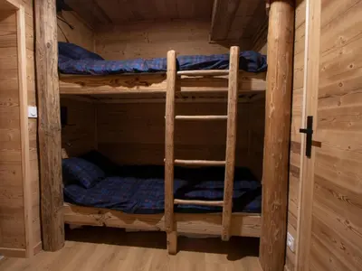 a bedroom with two bunk beds in a log cabin at Très bel appartement spacieux in Les Carroz d'Araches