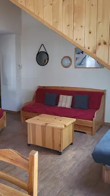 a living room with a red couch and a coffee table at Next to the ski lift! *3bed Apt* sleeps 8* Parking* Pool in Saint-Gervais-les-Bains